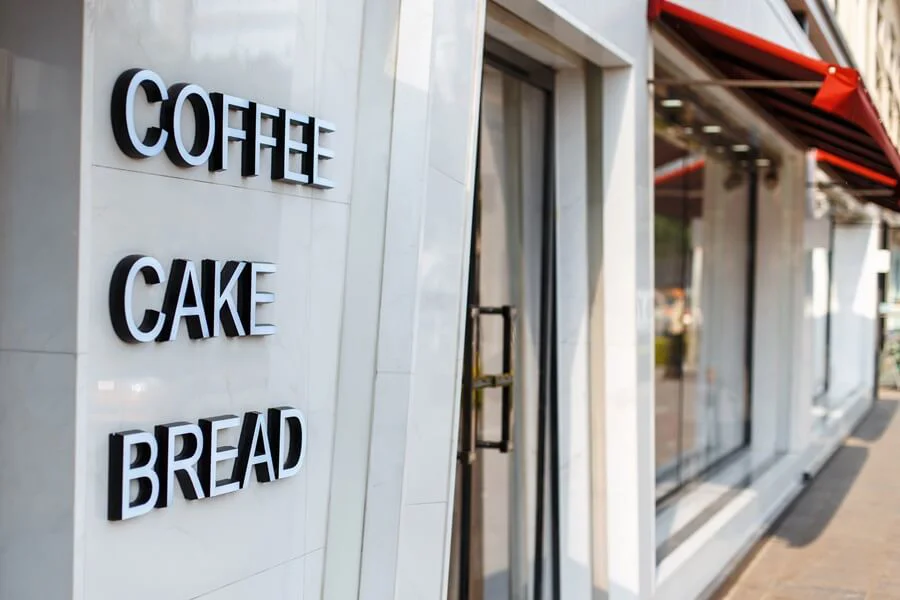 A modern coffee cake and bread signage on white marble.
